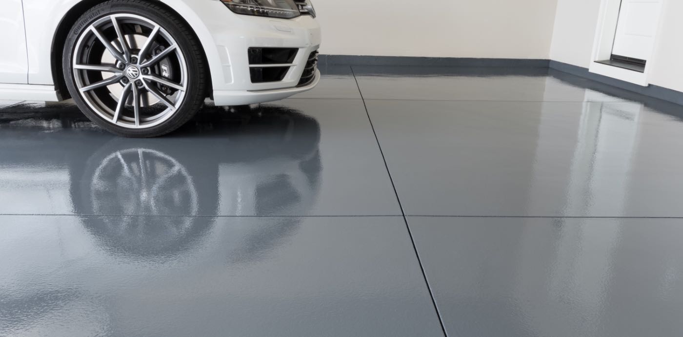 white car in garage with grey epoxied garage floor